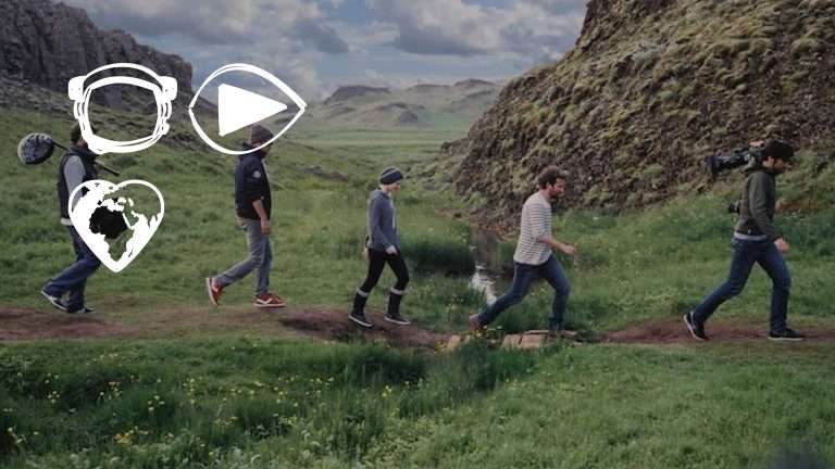 Een groepje filmmakers dat door een berglandschap loopt