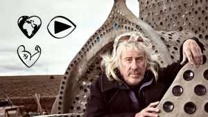 Mike Reynolds in front of an Earthship building